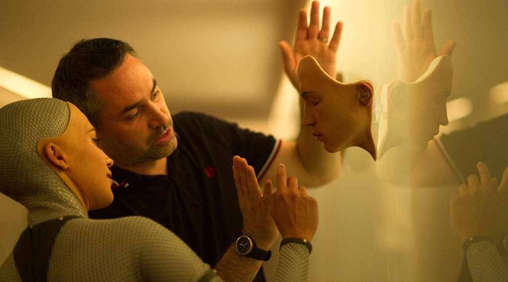 Alex Garland gestures toward Alicia Vikander, dressed as the android Ava, during filming of Ex Machina.