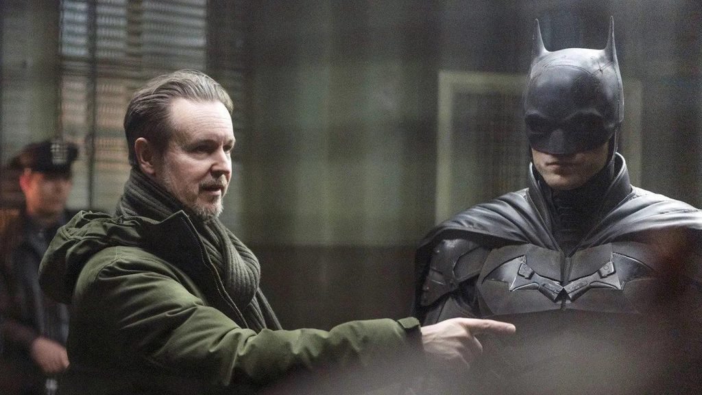 Matt Reeves gestures toward Robert Pattinson in Batman costume during filming.