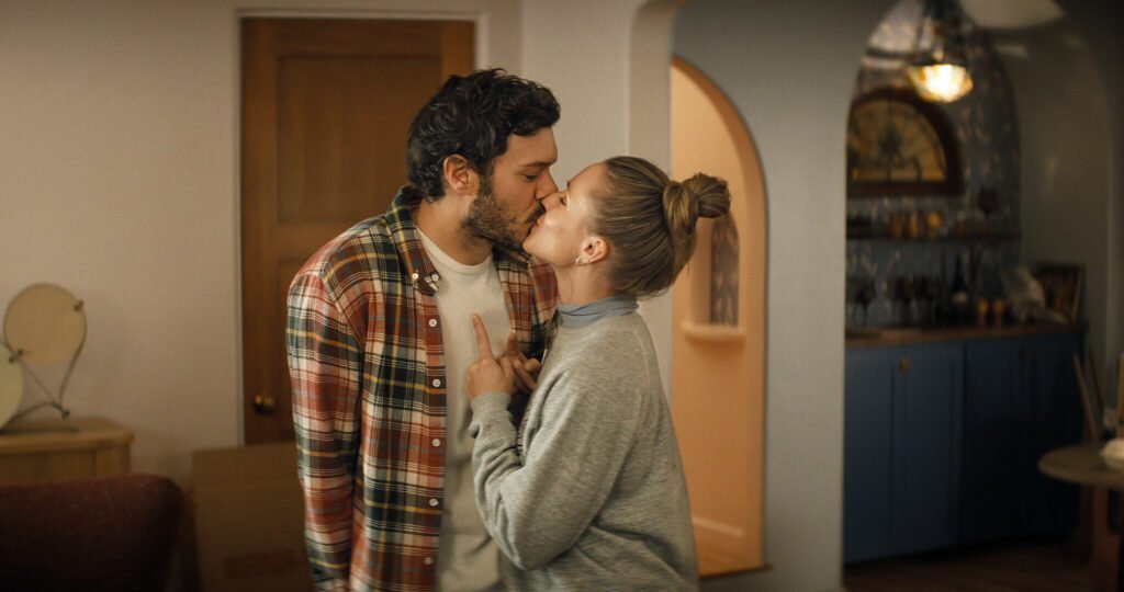Adam Brody as Noah and Kristen Bell as Joanne sharing a kiss indoors in a scene from Nobody Wants This Season 3.